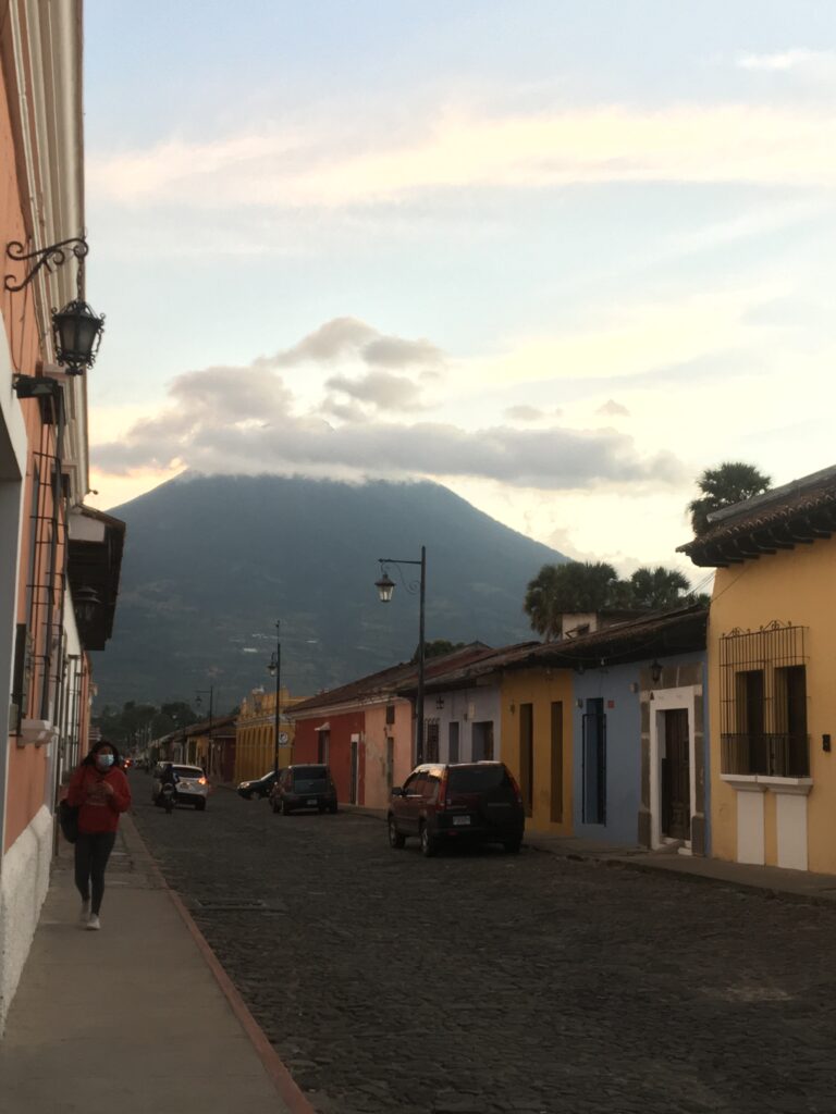 Una calle en Antigua Guatemala, con un volcaán de fondo, una de las cosas que ver en Guatemala