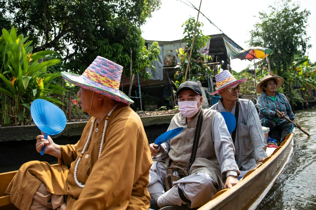 Como Viajar Barato: 5 Pasos para Viajar con Poco Dinero 7 a group of people in a boat with a hat on