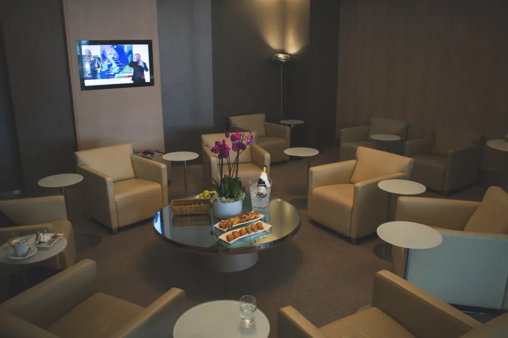 Como Acceder a Salas VIP en Aeropuertos (Acceso a Lounge Aeropuertos) 2 white sofa chairs near tv