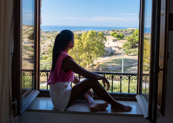 29 Things Not to Do in Italy: Avoid These Mistakes 22 woman looking out the window of an agriturismo place in Italy