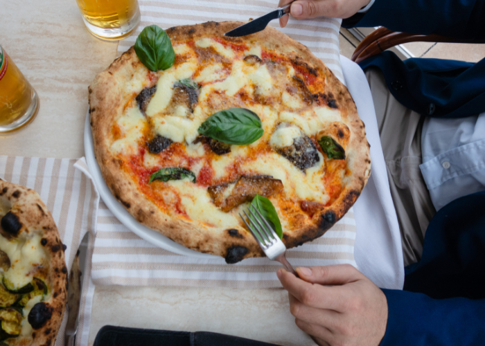 29 Things Not to Do in Italy: Avoid These Mistakes 25 a man eating pizza with knife and fork in Italy