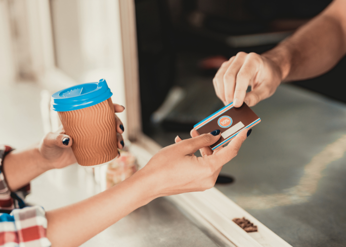a person buying a coffee with a credit card