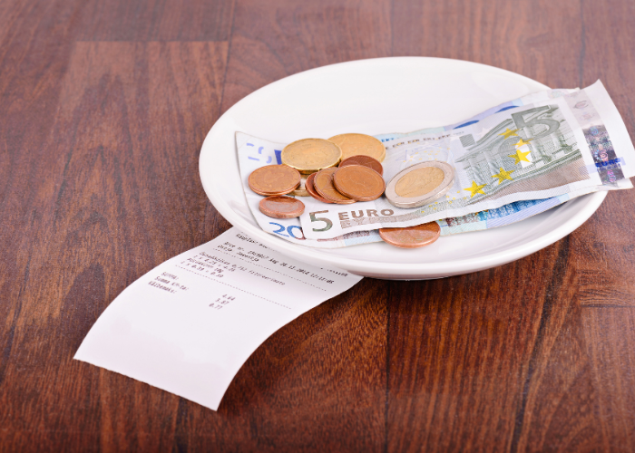 euros on a plate while tipping in Italy