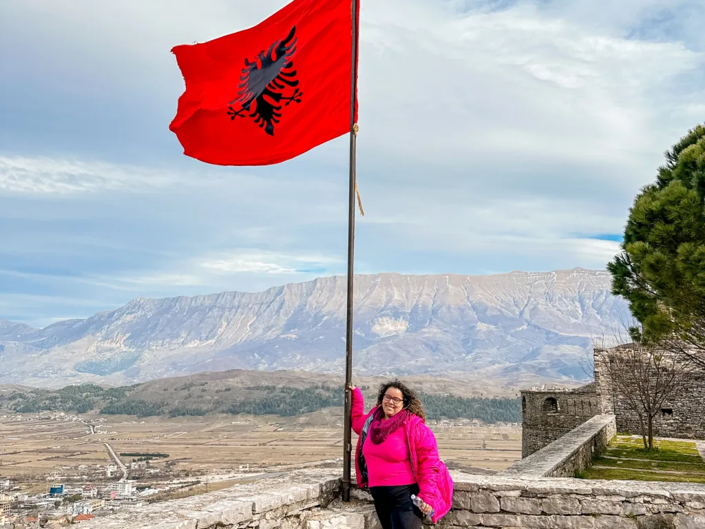 Viajar a Albania: guía completa con costos, rutas y seguridad 3 Brenda holding the Albanian flag in the Gjrokaster Castle
