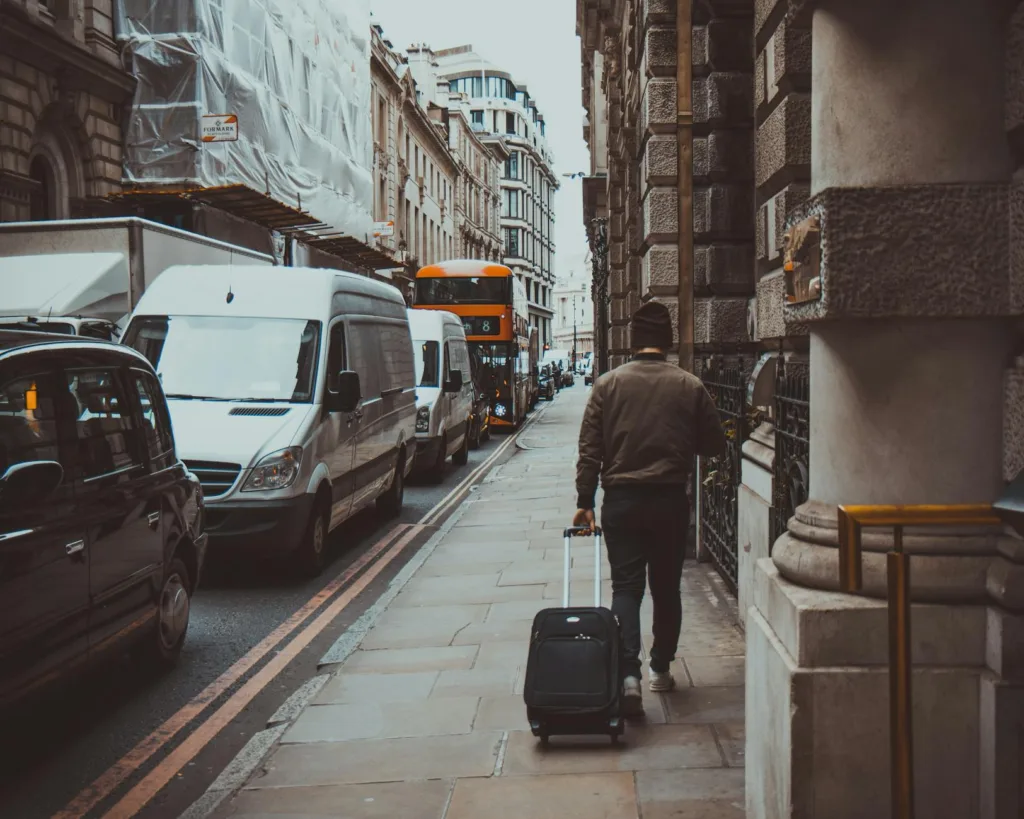 Where to Store Luggage When Traveling in 2026 2 man in brown jacket holding black travel luggage