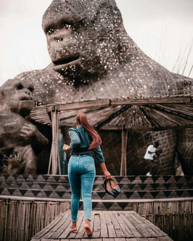 Best Ideas for Solo Trips in 2026 4 woman walking towards a statue of a giant gorilla with her shoes in hands