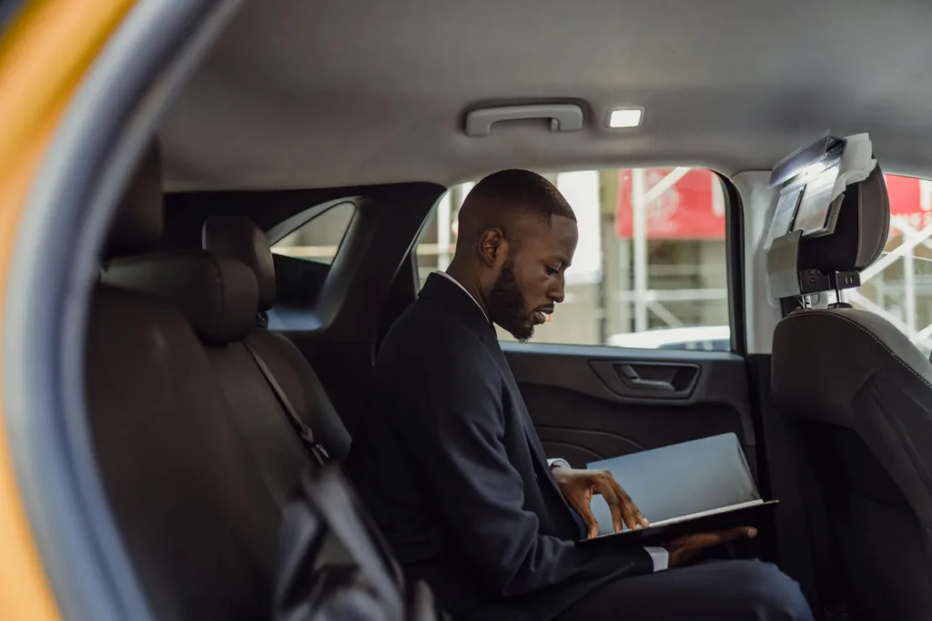 How to Choose Reliable Airport Cabs in 2025 2 man sitting with documents in car
