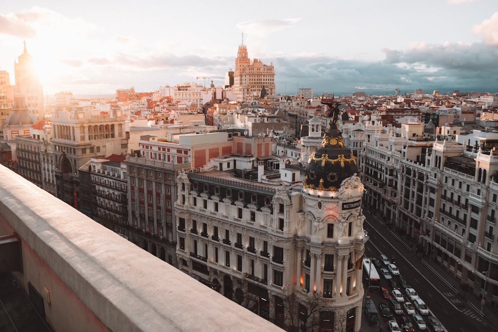 10 Rutas en Tren por Europa que Debes Hacer 13 Breathtaking view of Madrid's skyline at sunset featuring the Metropolis Building.