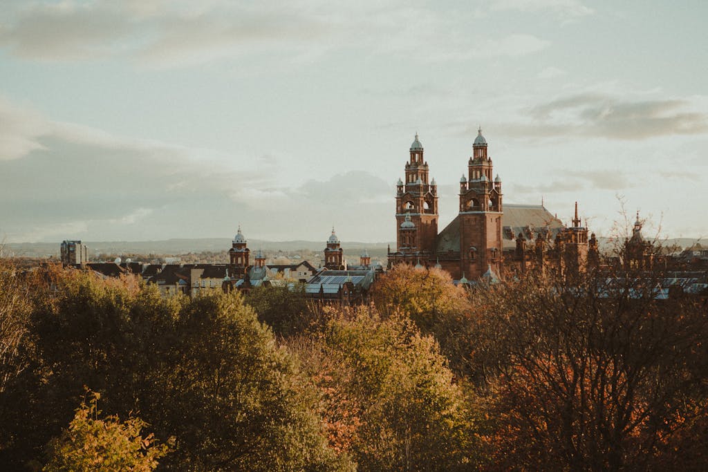 10 Rutas en Tren por Europa que Debes Hacer 9 Scenic view of Kelvingrove Museum surrounded by autumn foliage in Glasgow, Scotland.