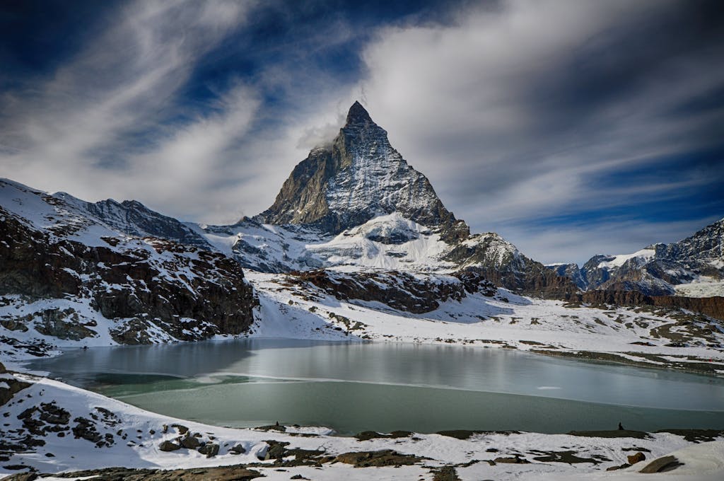10 Rutas en Tren por Europa que Debes Hacer 18 Scenic winter view of the Matterhorn mountain with a lake, perfect for adventure and travel imagery.
