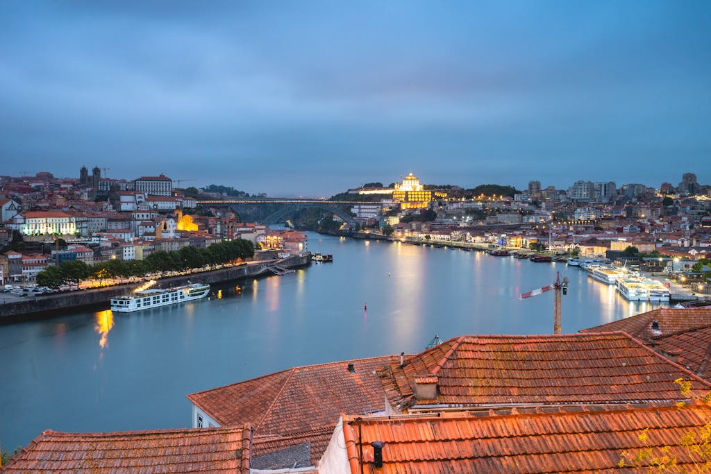 10 Rutas en Tren por Europa que Debes Hacer 8 Stunning view of Porto cityscape and Douro River at twilight, highlighting Portugal's architectural beauty.