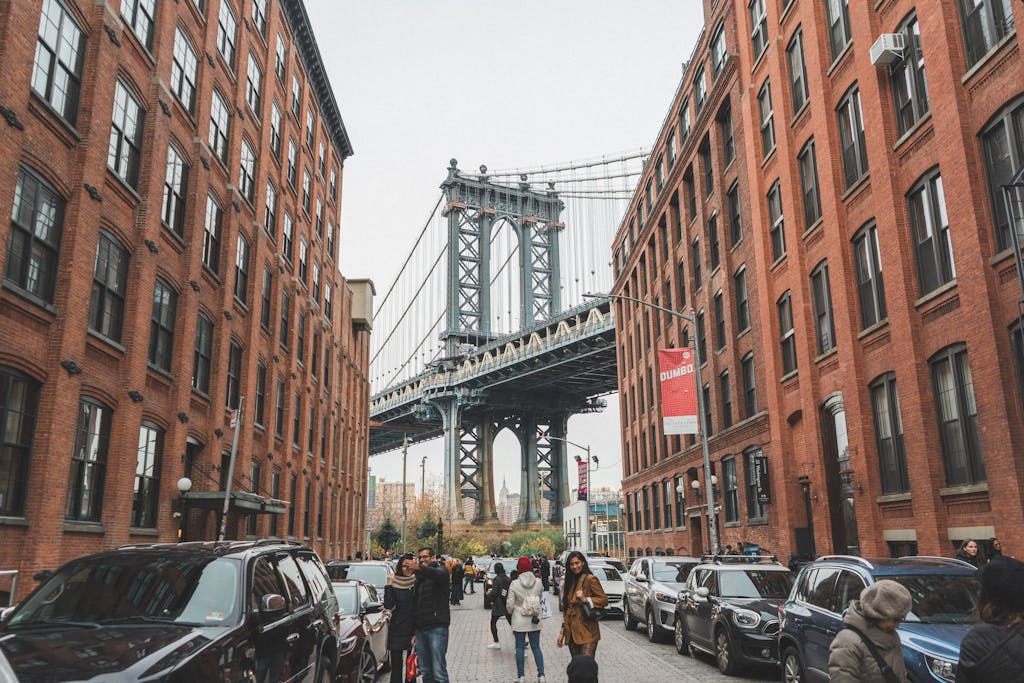 The Ultimate First Time in New York City Guide 8 Scenic view of the Manhattan Bridge framed by urban architecture in DUMBO, Brooklyn, NYC.
